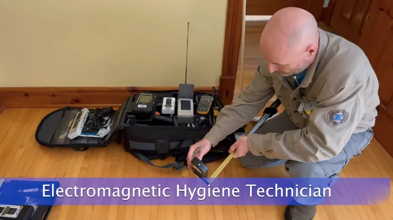Electromagnetic hygiene technician measuring EMF sources in a home